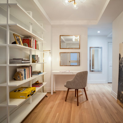Trendy medium tone wood floor and brown floor hallway photo in New York with white walls