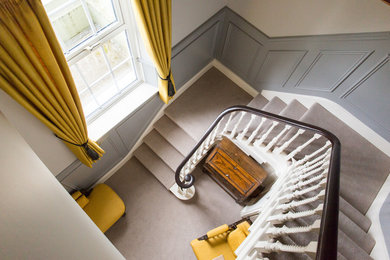 Пример оригинального дизайна: большой коридор в классическом стиле с серыми стенами и ковровым покрытием