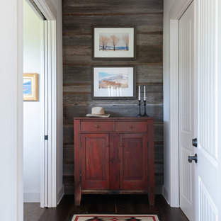 Idée de décoration pour un couloir sud-ouest américain de taille moyenne avec un mur blanc, un sol en bois foncé et un sol marron.