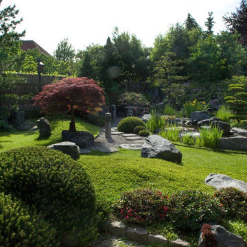 Japansk haveanlæg med vand, sten og planter i harmoni
