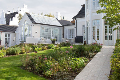 Klassisk villa med nyt orangeri, hvor gennemgående linjer bringer ro i haveanlæg