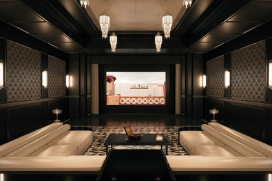 На фото: большой изолированный домашний кинотеатр в классическом стиле с черными стенами, проектором и разноцветным полом