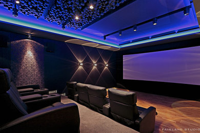 Exemple d'une grande salle de cinéma tendance ouverte avec un sol en bois brun et un écran de projection.