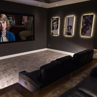 Diseño de cine en casa cerrado, contemporáneo, grande, con paredes negras, moqueta y pantalla de proyección