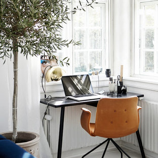 Inspiration för ett litet skandinaviskt hemmabibliotek, med vita väggar, målat trägolv och ett fristående skrivbord