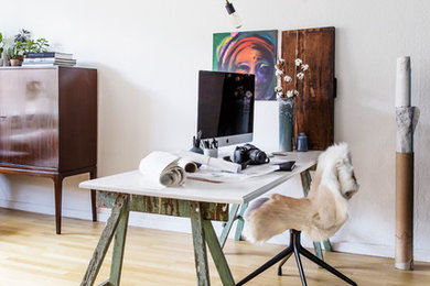 Inspiration för minimalistiska hemmabibliotek, med vita väggar, ljust trägolv och ett fristående skrivbord