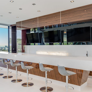 Large minimalist u-shaped porcelain tile and white floor home bar photo in Los Angeles with a drop-in sink, recessed-panel cabinets, medium tone wood cabinets, quartz countertops, white backsplash, quartz backsplash and white countertops
