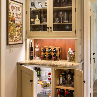 Ispirazione per un piccolo angolo bar country con ante a filo, ante beige, top in granito, paraspruzzi marrone e pavimento in legno massello medio