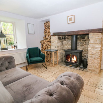 A comfortable, velvet seating area with log burner in an open plan bar and dinin