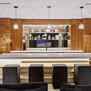 This is an example of a large contemporary single-wall home bar in Gold Coast - Tweed with flat-panel cabinets, light wood cabinets, quartz benchtops, white splashback, mirror splashback, dark hardwood floors, brown floor, grey benchtop and a drop-in sink.