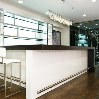 Large trendy u-shaped dark wood floor seated home bar photo in New York with glass countertops and white backsplash
