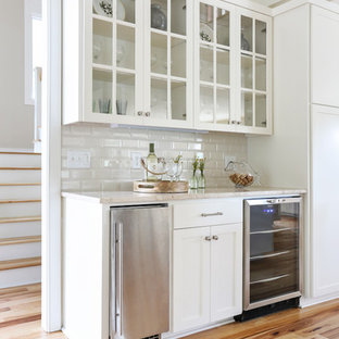 Idee per un angolo bar stile marinaro con ante di vetro, ante bianche, paraspruzzi bianco, paraspruzzi con piastrelle diamantate, parquet chiaro e pavimento beige