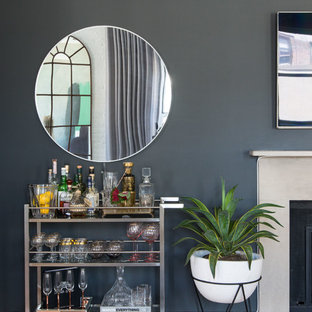 Modelo de bar en casa con carrito de bar tradicional renovado con suelo de madera en tonos medios y suelo marrón