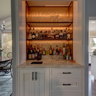 Esempio di un angolo bar con lavandino costiero di medie dimensioni con lavello sottopiano, ante con riquadro incassato, ante bianche, top in quarzite, paraspruzzi marrone, paraspruzzi con piastrelle di vetro e parquet scuro