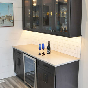 Idee per un angolo bar con lavandino design di medie dimensioni con nessun lavello, ante di vetro, ante in legno bruno, top in superficie solida, paraspruzzi bianco, paraspruzzi con piastrelle diamantate, parquet chiaro, pavimento grigio e top beige