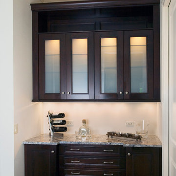 Bar cabinetry with glass door inserts and granite countertop