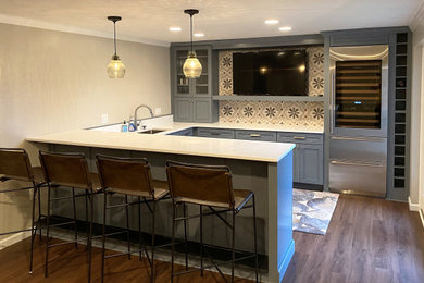 Seated home bar - mid-sized contemporary u-shaped vinyl floor and brown floor seated home bar idea in Other with an undermount sink, flat-panel cabinets, blue cabinets, quartz countertops, beige backsplash, cement tile backsplash and white countertops