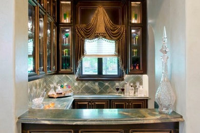 Design ideas for a medium sized classic u-shaped wet bar in Houston with glass-front cabinets, dark wood cabinets, marble worktops, green splashback and stone tiled splashback.