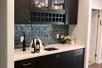 Wet bar - single-wall wet bar idea in Los Angeles with an undermount sink, flat-panel cabinets, dark wood cabinets, quartz countertops and glass tile backsplash