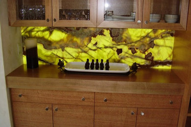 Example of a mid-sized home bar design in Denver with light wood cabinets, wood countertops and glass tile backsplash