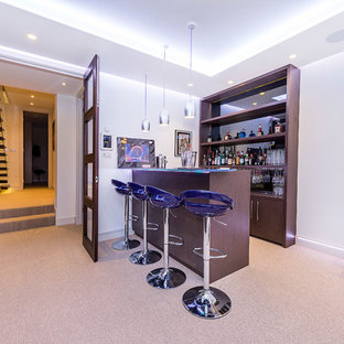 Medium sized contemporary single-wall breakfast bar in London with open cabinets, dark wood cabinets, mirror splashback, carpet, beige floors and glass worktops.
