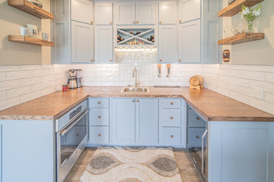 Inspiration for a small craftsman u-shaped vinyl floor and brown floor wet bar remodel in St Louis with a drop-in sink, shaker cabinets, gray cabinets, wood countertops and ceramic backsplash