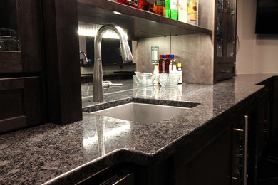 Example of a mid-sized transitional u-shaped linoleum floor and black floor seated home bar design in Chicago with an undermount sink, glass-front cabinets, dark wood cabinets, granite countertops and black countertops