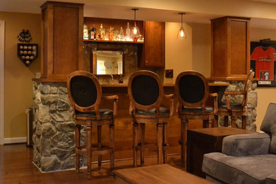 Seated home bar - mid-sized rustic galley medium tone wood floor and brown floor seated home bar idea in DC Metro with an undermount sink, shaker cabinets, medium tone wood cabinets, wood countertops, beige backsplash and ceramic backsplash