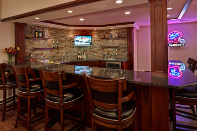 Seated home bar - huge traditional u-shaped seated home bar idea in Philadelphia with raised-panel cabinets, brown cabinets, granite countertops and multicolored backsplash