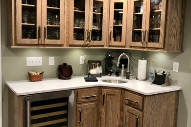 Example of a wet bar design in St Louis with an undermount sink, recessed-panel cabinets, gray cabinets, quartz countertops and white countertops