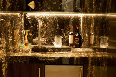 Small trendy single-wall wet bar photo in New York with an undermount sink, flat-panel cabinets, dark wood cabinets, granite countertops, multicolored backsplash and stone slab backsplash