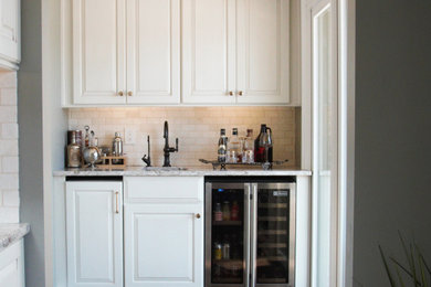 Inspiration for a small transitional single-wall dark wood floor wet bar remodel in Other with an undermount sink, raised-panel cabinets, white cabinets, quartz countertops, white backsplash, stone tile backsplash and multicolored countertops