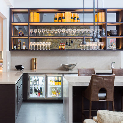 Seated home bar - large contemporary l-shaped gray floor seated home bar idea in Melbourne with dark wood cabinets, beige backsplash, stone slab backsplash, gray countertops and open cabinets