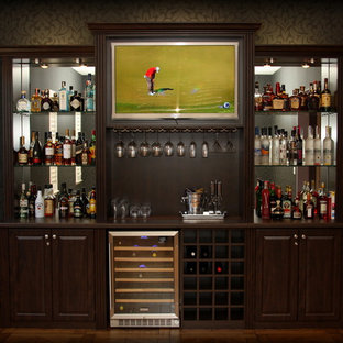 Ispirazione per un angolo bar chic di medie dimensioni con nessun lavello, ante in legno bruno, top in laminato, ante con bugna sagomata, paraspruzzi a specchio, pavimento in legno massello medio e pavimento marrone