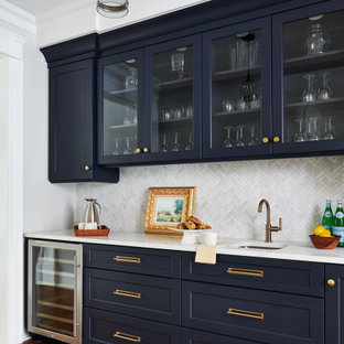 Immagine di un angolo bar con lavandino chic con lavello sottopiano, ante in stile shaker, ante blu, paraspruzzi grigio, pavimento in legno massello medio, pavimento marrone e top bianco