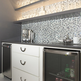 Exemple d'un bar de salon avec évier parallèle rétro de taille moyenne avec un évier encastré, un placard à porte plane, des portes de placard blanches, un plan de travail en quartz modifié, une crédence multicolore, une crédence en carreau de verre, un sol en carrelage de porcelaine, un sol blanc et un plan de travail gris.