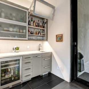 Diseño de bar en casa con fregadero lineal, contemporáneo, con fregadero bajoencimera, armarios con paneles lisos, puertas de armario grises, salpicadero verde, suelo negro y encimeras blancas