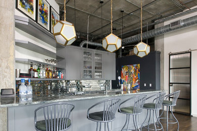 Idee per un grande bancone bar moderno con lavello sottopiano, ante in stile shaker, ante grigie, paraspruzzi a specchio, parquet scuro, top in granito e paraspruzzi grigio