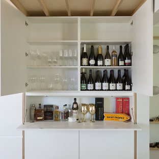 Photo of a contemporary single-wall wet bar in Sydney with flat-panel cabinets, white cabinets, white splashback and white benchtop.