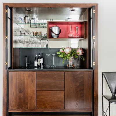Small transitional single-wall dark wood floor and brown floor wet bar photo in Boston with an undermount sink, flat-panel cabinets, dark wood cabinets, black backsplash, soapstone countertops and mirror backsplash
