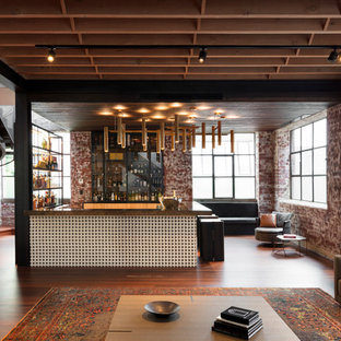 This is an example of a mid-sized industrial u-shaped seated home bar in Melbourne with an undermount sink, glass-front cabinets, light wood cabinets, onyx benchtops, brick splashback, medium hardwood floors, brown floor and brown benchtop.