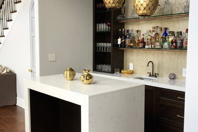 Wet bar - small contemporary galley medium tone wood floor and brown floor wet bar idea in Los Angeles with a drop-in sink, recessed-panel cabinets, brown cabinets, quartz countertops and beige backsplash