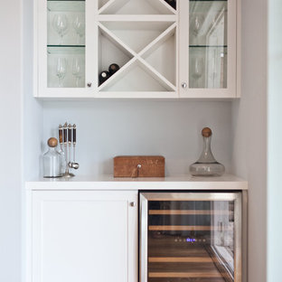 Esempio di un piccolo angolo bar stile marinaro con ante bianche, top in laminato e pavimento in legno massello medio