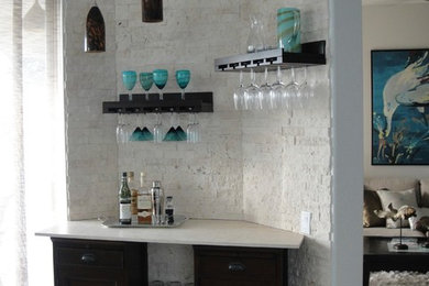 Home bar - small coastal single-wall ceramic tile home bar idea in Miami with no sink, recessed-panel cabinets, black cabinets, limestone countertops, white backsplash and brick backsplash