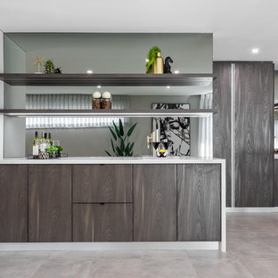 Contemporary single-wall wet bar in Perth with flat-panel cabinets, dark wood cabinets, mirror splashback, concrete floors, grey floor and white benchtop.