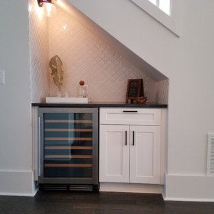Idee per un piccolo angolo bar con lavandino tradizionale con nessun lavello, ante in stile shaker, ante bianche, top in superficie solida, paraspruzzi bianco, paraspruzzi con piastrelle in ceramica e parquet scuro