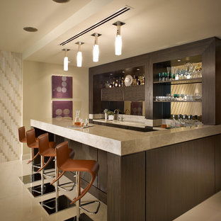 Immagine di un bancone bar design con ante in legno bruno e paraspruzzi a specchio