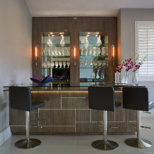 Immagine di un bancone bar minimal di medie dimensioni con top in vetro, paraspruzzi a specchio, ante lisce, ante in legno scuro e pavimento bianco