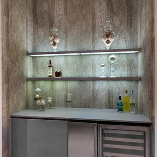 Foto di un piccolo angolo bar con lavandino design con ante lisce, ante grigie, top in quarzo composito e pavimento in travertino