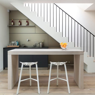Immagine di un angolo bar con lavandino contemporaneo con lavello sottopiano, ante lisce, paraspruzzi beige, pavimento in legno massello medio e pavimento beige